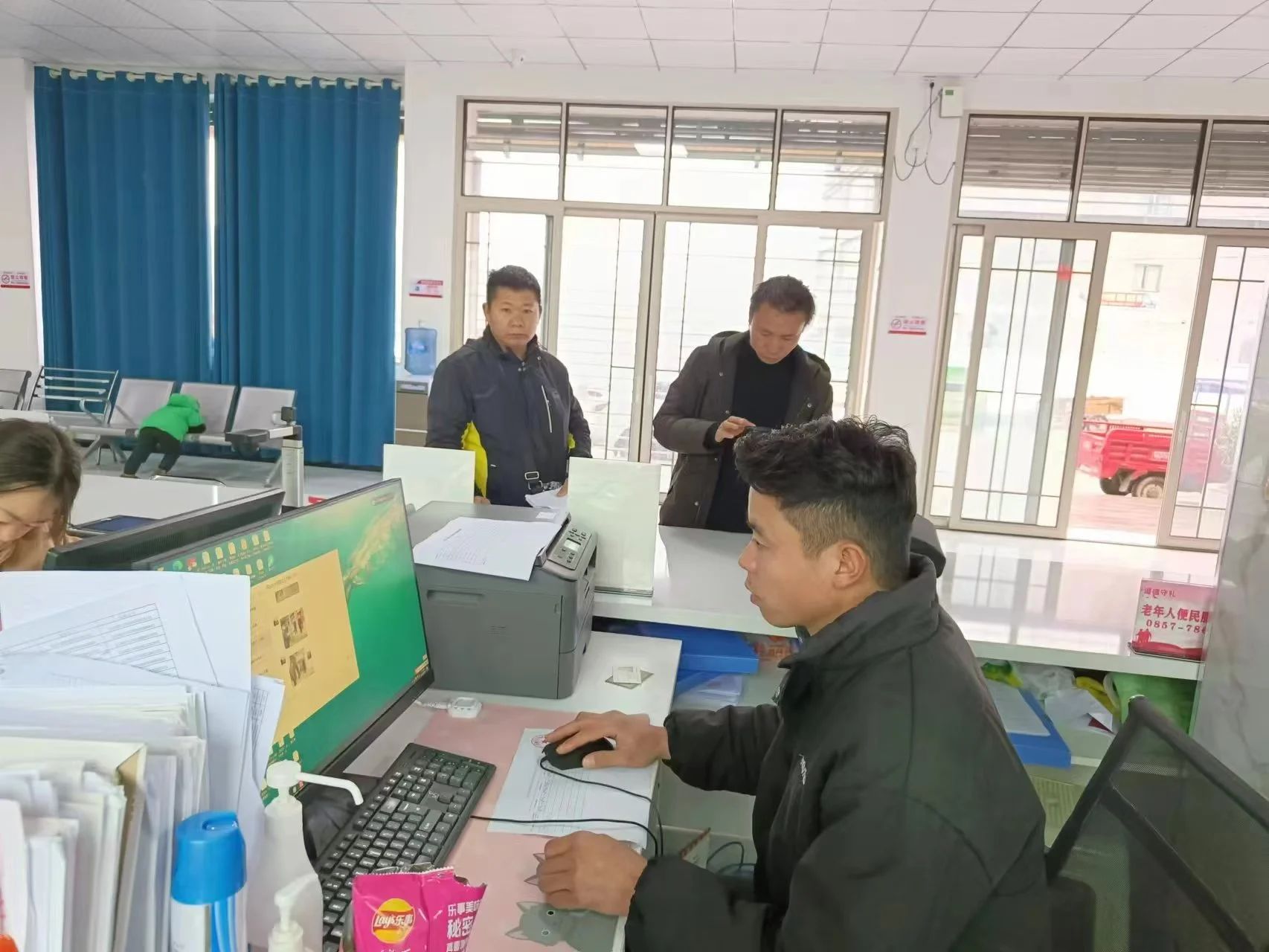 图为贵州省毕节市织金县茶店乡专职委员王庆红正在为前来办事的残疾人家属办理事务